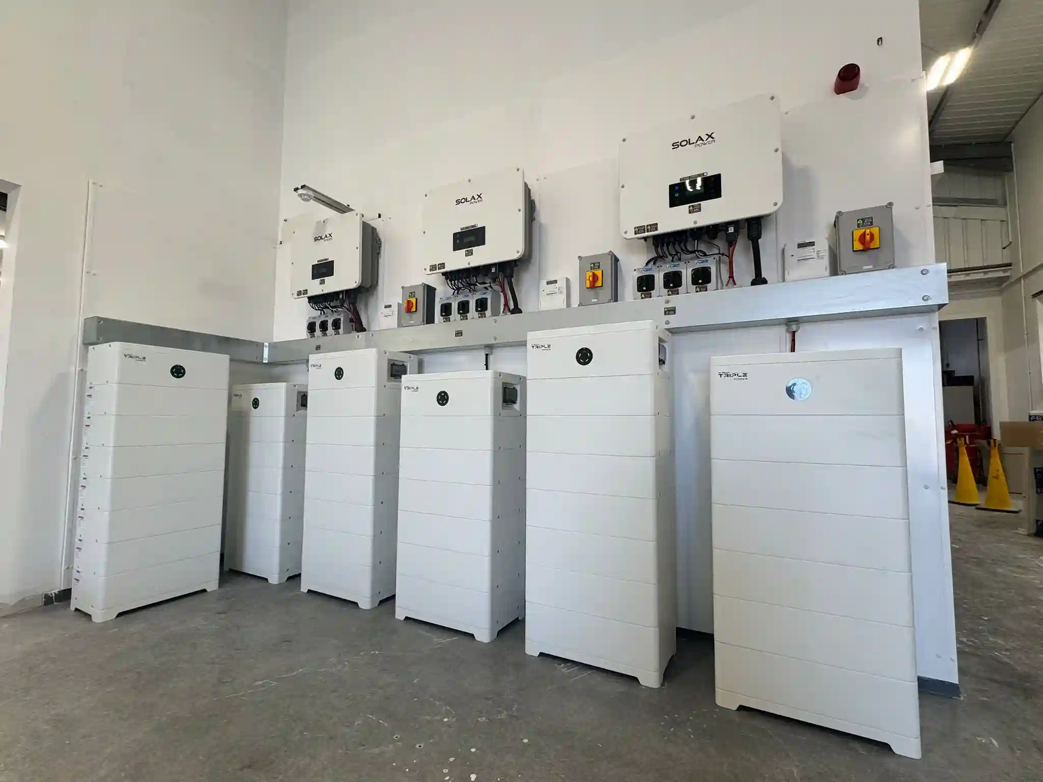 A bank of SolaX battery storage units and hybrid inverters