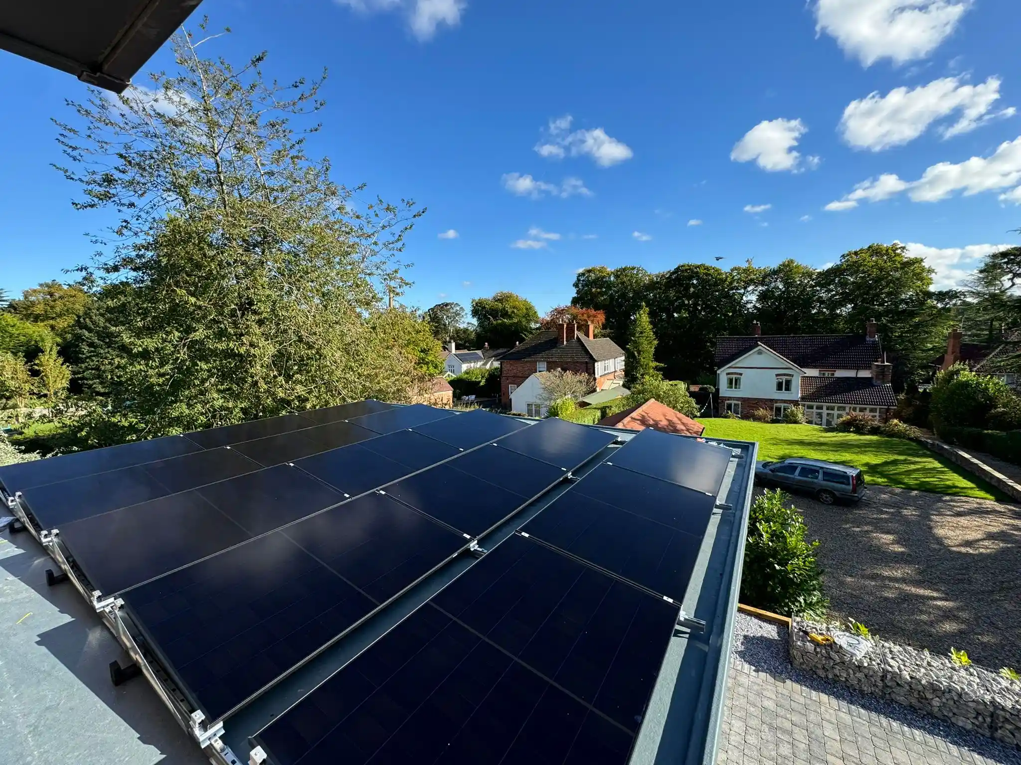 All black solar panels on a tilt frame on a domestic flat roof